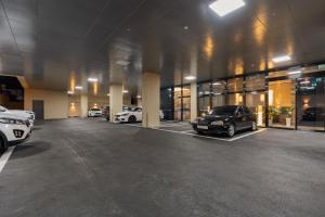 a parking lot with two cars parked inside of a building at 구미 더혜밀호텔 in Gumi