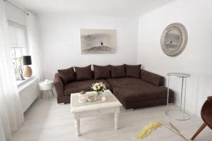 a living room with a brown couch and a table at Huus an`t Dörpsdiek in Krummhörn +35 photos