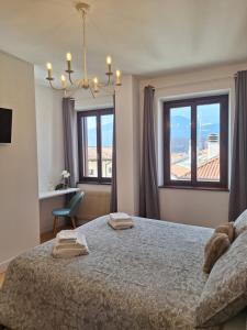 a bedroom with a large bed and two windows at Affittacamere La Polse in Osoppo