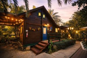 a cabin with a porch with lights on it at family cabin in Menaẖemya