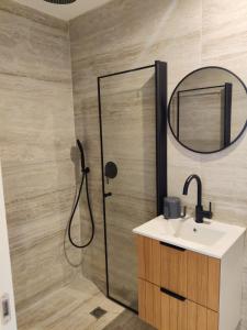 a bathroom with a shower with a sink and a mirror at El Yam in Netanya +35 photos