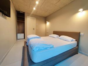 a small bedroom with a bed with white sheets and pillows at El Yam in Netanya