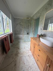 a large bathroom with a sink and a shower at Pouto Farms Packhouse - Coastal Farmhouse in Pouto +14 photos