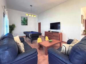 a living room with couches and a pool table at Villa Solara in Caleta De Fuste