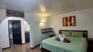 a bedroom with a bed with a heart pillow on it at Lemongarden in Ko Lanta +31 photos