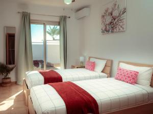 two beds sitting in a room with a window at Villa Solara in Caleta De Fuste +25 photos