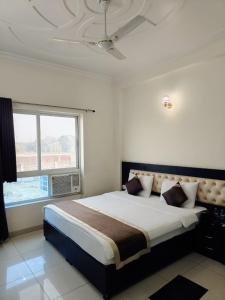 a bedroom with a large bed with a large window at J P PALACE in Kushinagar