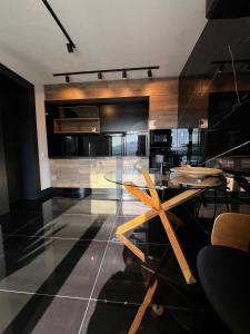 a dining room with a glass table and a kitchen at Mountain View Home in Zalău