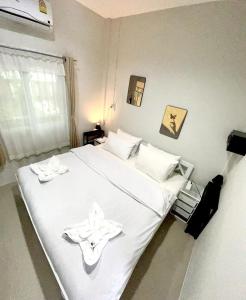 a bedroom with a white bed with two dishes on it at Yada House s&h in Nai Yang Beach