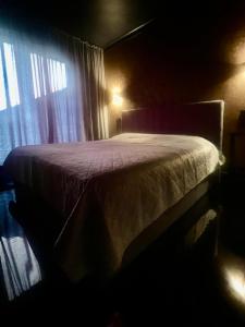 a bed in a dark room with a window at Mountain View Home in Zalău