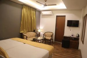 a hotel room with a bed and a tv at Hotel La Hotera in Hyderabad +16 photos
