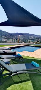 a group of lounge chairs sitting next to a swimming pool at Maximos Luxury Villa Monagri Limassol in Monagri