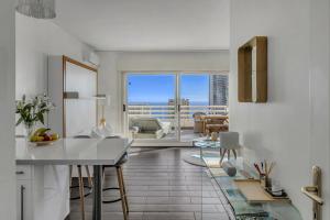 a kitchen with a table and a view of a living room at Beausoleil near Monaco - Cosy Studio with Sea view in Beausoleil