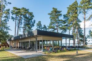 a building with a black roof with trees in the background at Apartamenty Niegocin in Wilkasy
