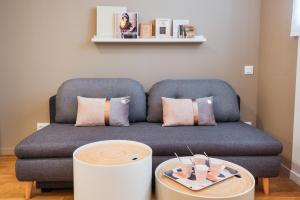 a living room with a couch and a table at Studios Part-Dieu Gare - HomaLyon in Lyon