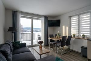 a living room with a couch and a table at Apartmány Sunny hill in Frymburk