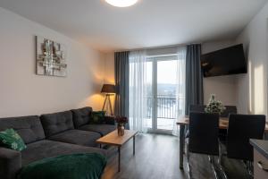 a living room with a couch and a table at Apartmány Sunny hill in Frymburk