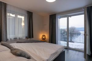 a bedroom with two beds and a large window at Apartmány Sunny hill in Frymburk