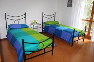 dos camas sentadas una al lado de la otra en una habitación en Casa Mattia by Holiday World, en Bellano