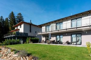 a large white building with a lawn in front of it at Apartmány Sunny hill in Frymburk