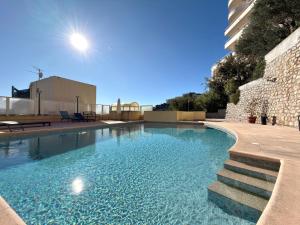 a swimming pool with blue water in a building at Beausoleil near Monaco - Cosy Studio with Sea view in Beausoleil