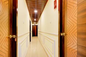a hallway with white walls and a wooden ceiling at Hotel O Hotel R Pacific in Hyderabad
