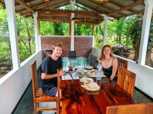 a man and a woman sitting at a table with food at Diamond Resorts in Udawalawe
