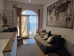ein Wohnzimmer mit Sofa und großem Fenster in der Unterkunft Oyster 2 Beachfront bliss in Qbajjar