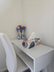 a white table with two bottles of water and flowers at Hillcrest Home in Hamilton +28 photos