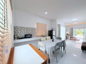 a kitchen and dining room with a table and chairs at Ban Belife14 in Ban Tha Chin (1)