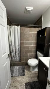 a bathroom with a toilet and a shower curtain at apartment unit in Spokane