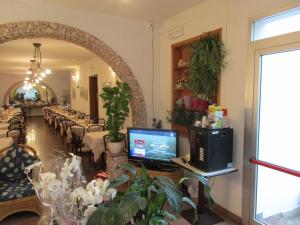 a dining room with a table with a computer on a desk at Hotel Pensione Ornella in Cesenatico