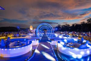 a night view of a bar with blue lights at Kora Beach Resort Phuket in Bang Tao Beach