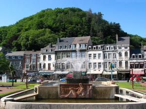 una fontana nel mezzo di una città con edifici di B&B Le calme sur les hauteurs de Spa a Tiège