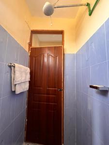 a bathroom with a wooden door and a towel at The Mountain Gaze in Nyeri +11 photos