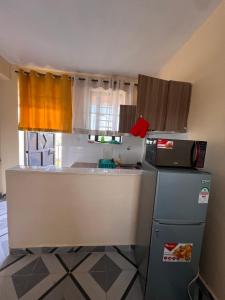 a small kitchen with a refrigerator and a microwave at The Mountain Gaze in Nyeri