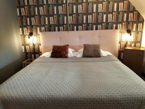 ein Schlafzimmer mit einem großen Bett und Büchern an der Wand in der Unterkunft Boutique Hotel Butler in Zuienkerke