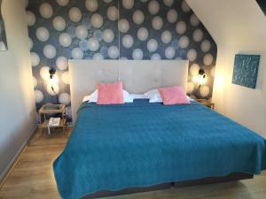 ein Schlafzimmer mit einem blauen Bett mit zwei rosa Kissen in der Unterkunft Boutique Hotel Butler in Zuienkerke + 71 Fotos