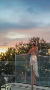 a woman in a white dress standing on a balcony at Kora Beach Resort Phuket in Bang Tao Beach +175 photos