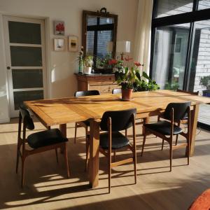 a wooden table and chairs in a room at Tycoat in Carantec