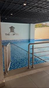 a swimming pool with a sign on the side of a building at Homiq Stays near UN & Village Market - 1 bedroom in Ruaka