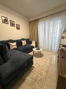 a living room with a couch and a table at Homiq Stays near UN & Village Market - 1 bedroom in Ruaka