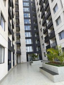 an empty courtyard in front of a tall building at Homiq Stays near UN & Village Market - 1 bedroom in Ruaka
