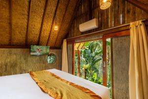 a bed in a room with a window at Vana Nugraha Villas in Tampaksiring