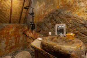 a stone bathroom with a sink in a stone wall at Vana Nugraha Villas in Tampaksiring