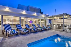- un ensemble de chaises assises sur une terrasse à côté d'une piscine dans l'établissement Villa Gaia - Sunset Views, Indoor Heated Pool, Sauna and Games Room, à Mellieħa
