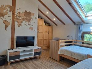 a bedroom with a tv and a map of the world on the wall at River Garden in Beli Osŭm
