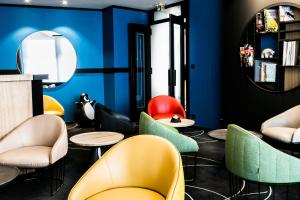 a barber shop with colorful chairs and a mirror at Hostellerie Du Chapeau Rouge in Dijon