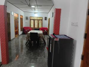 a living room with a table and chairs and a dining room at BG Guest House Jaffna in Tirunelveli East
