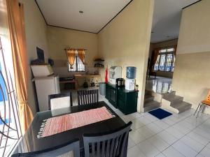 a kitchen with a table and a stove and refrigerator at Vila Biru Gundaling Brastagi in Berastagi